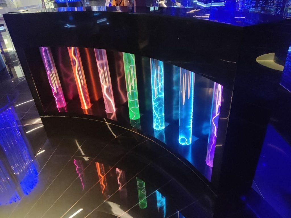 A display case with seven coloured plasma tubes at the Atom museum