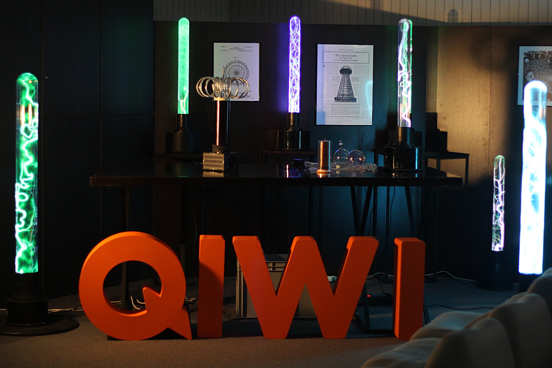 Плазменные колонны и катушка Тесла за логотипом QIWI