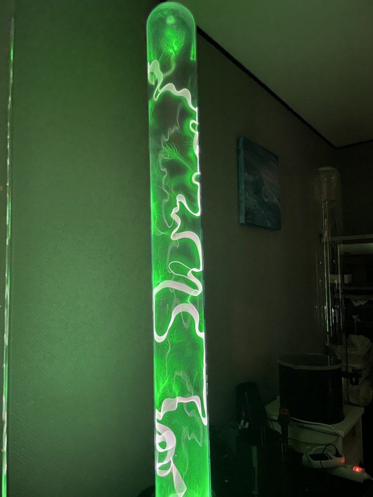 A Green Arrow plasma column in a room with dimmed light